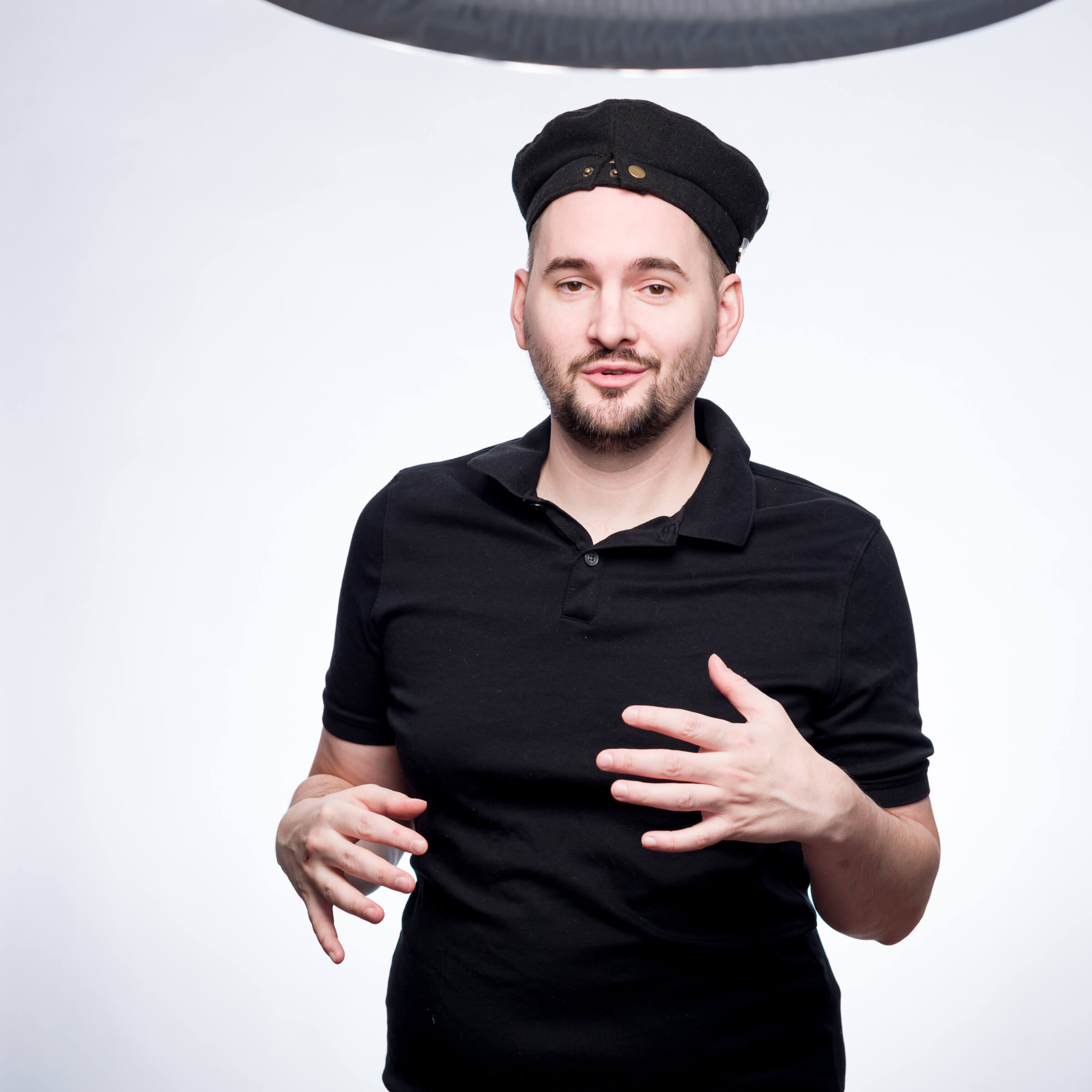 A man in a black hat is standing in front of an umbrella, showcasing his expertise in marketing management.